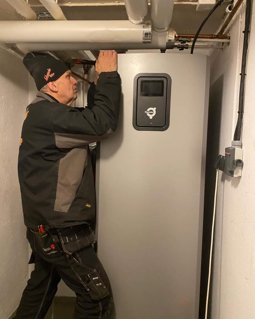 Personal installerar värmepump och säkerställer kvaliteten.